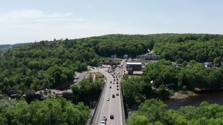 Low aerial shot flying over the bridge that links Minnesota and Wisconsin over the Saint Croix River at Taylors Falls. 4K