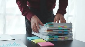 Businessman working in stacks of paperwork files for searching information unfinished documents about pile audit form on desk office and investigate financial doc in busy workload. - Powered by Shutterstock - Get 15% off with code: PIKWIZARD15