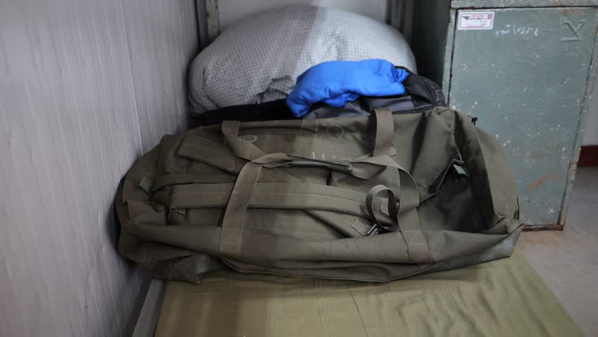 Soldier putting his personal effects on a bed, army backpack and uniform Royalty-Free Stock Footage #1106140957