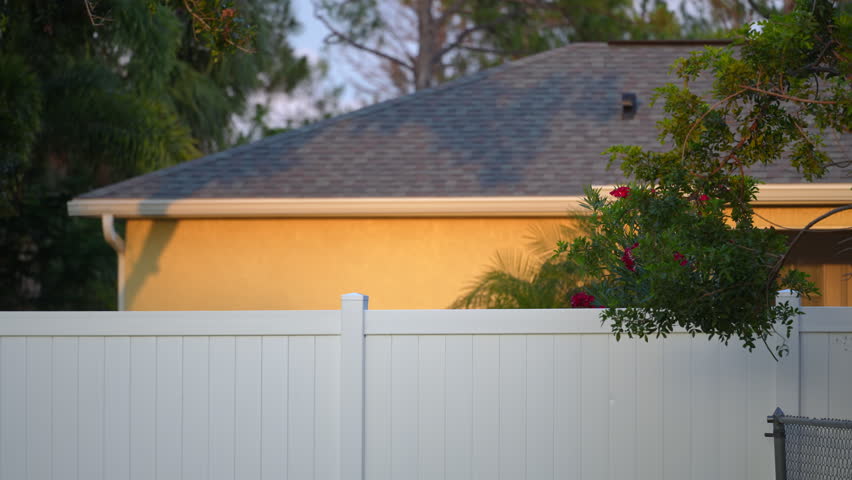 White plastic fence for back yard protection and privacy. Vinyl plank fencing in Florida Royalty-Free Stock Footage #1106143669