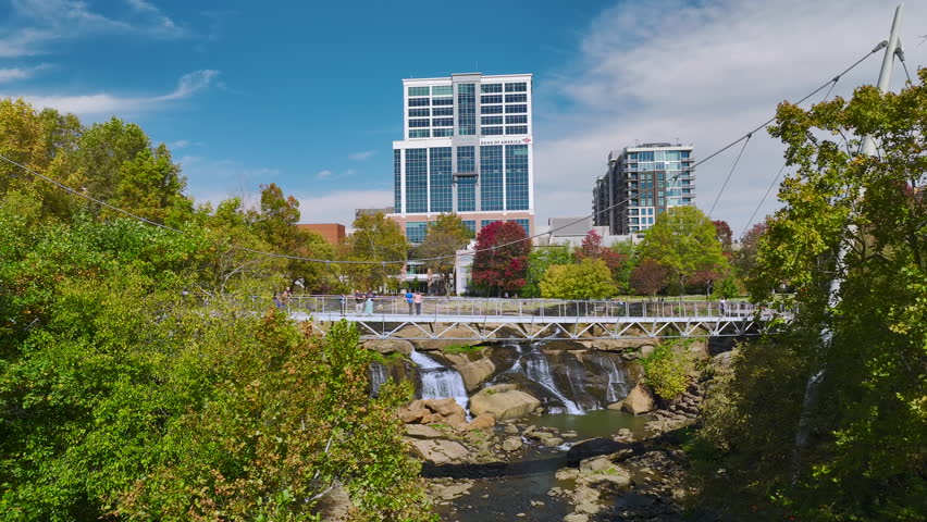 Aerial view of Reedy River Waterfalls in downtown of Greenville city in South Carolina. Falls Park riverwalk at Liberty bridge. American travel destination.