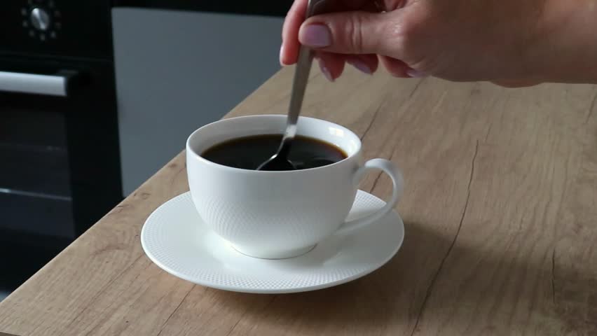 Stir the hot coffee in a cup with a spoo, Stock Video