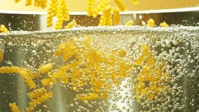 Super Slow Motion of Flying Italian Pasta Fusilli Into Water. Water is Boiling in Stainless Steel Pot. Filmed on high speed cinema camera, 1000 fps. - Powered by Shutterstock - Get 15% off with code: PIKWIZARD15