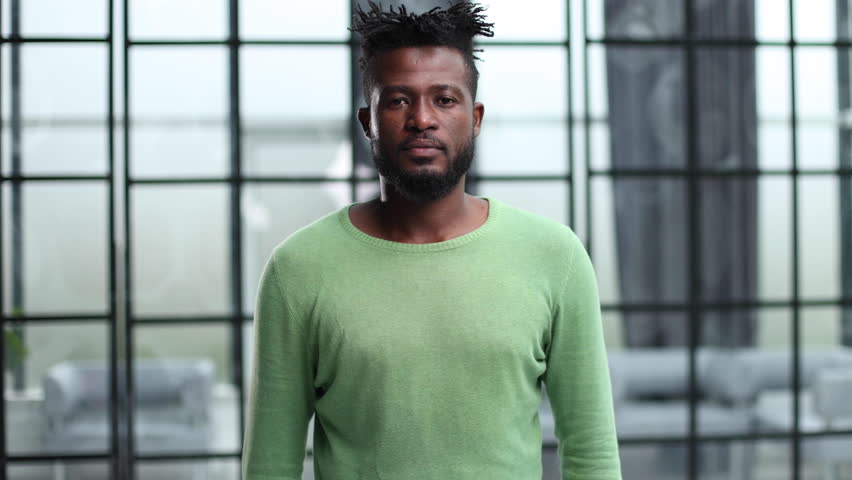 African American with crossed arms in a green sweater.