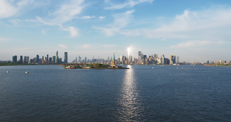 Aerial Hyperlapse Footage Passing the Statue of Liberty with Lower Manhattan Skyline Cityscape with Wall Street Office Architecture. Moving Time-Lapse of New York City Skyscrapers and Jersey City Royalty-Free Stock Footage #1106171135