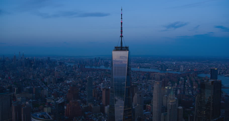 Late Evening Aerial Footage of a Camera Locked on Top of the One World Trade Center Skyscraper with Antenna. Helicopter Flying Around the Glass Building with a View on All Five New York City Boroughs Royalty-Free Stock Footage #1106171193
