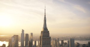 Sunset Aerial View of Empire State Building Spire and a Top Deck Tourist Observatory. New York City Business Center From Above. Helicopter Footage of an Architectural Wonder in Midtown Manhattan