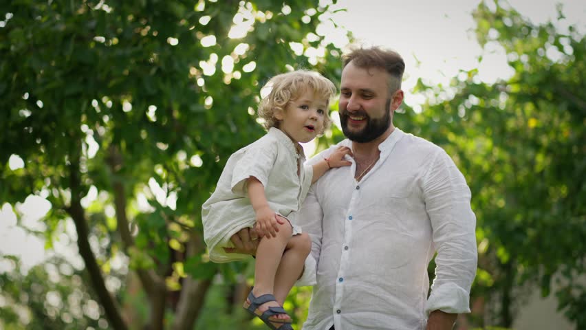 A man holds his child on one hand