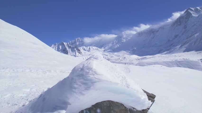 Aerial revealing view male trekker in red jacket walk downhill from hill top on Tilicho lake camp trail in Himalayas.Inspirational traveler adventurer travel solo explore asia.