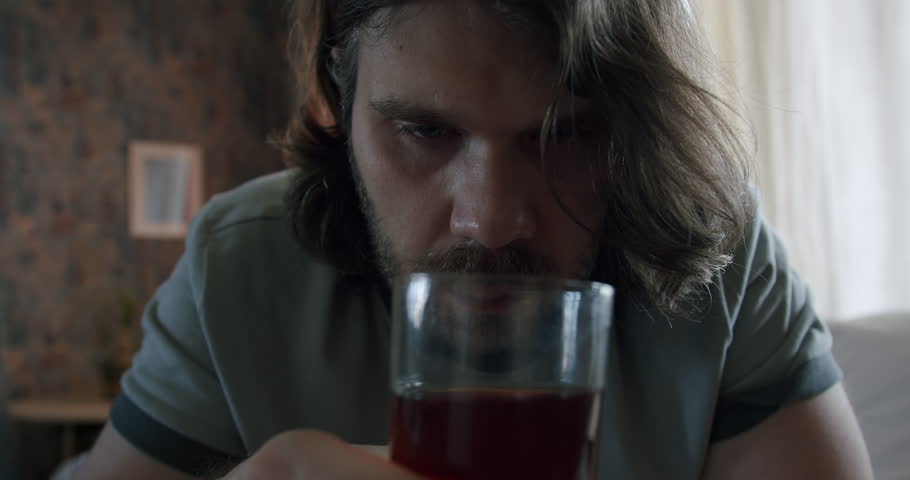 Man drinking alcohol daytime. Alcohol addiction problem. Abuse alcohol drinking. Glass of whiskey. Close up face of disturbed, troubled  man. Feeling angry, resentful, humiliated. Depressive thoughts Royalty-Free Stock Footage #1106178023