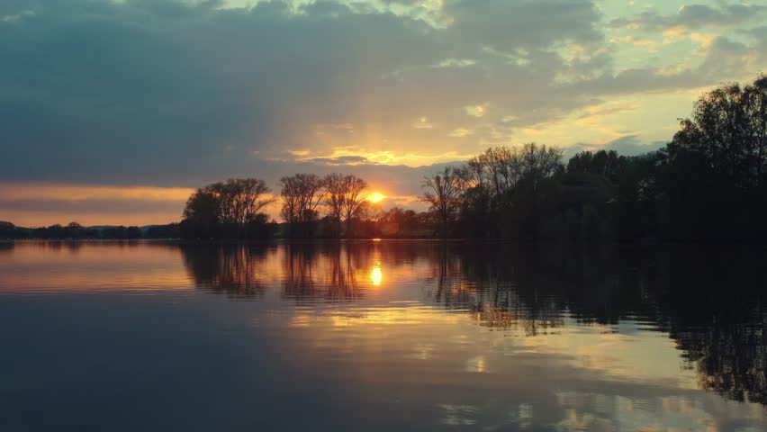 Beautiful panoramic sunset reflecting on small lake in Germany.