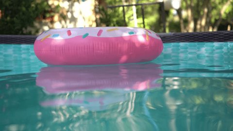 Inflable donut pool float circling in a private pool – Stockvideo
