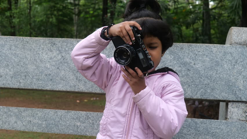 This video is about Indian 5-Year-Old Girl Taking Pictures with Camera Royalty-Free Stock Footage #1106196705