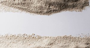 Video of close up of sand grains and copy space on white background. Sand, texture and pattern concept.