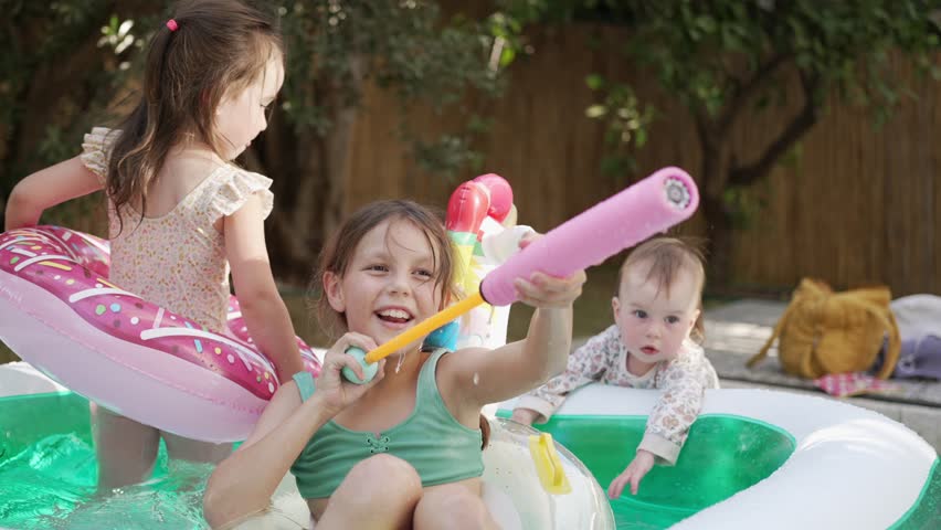  Group of Little Girls of Various Ages Play and Have Fun in a Pool