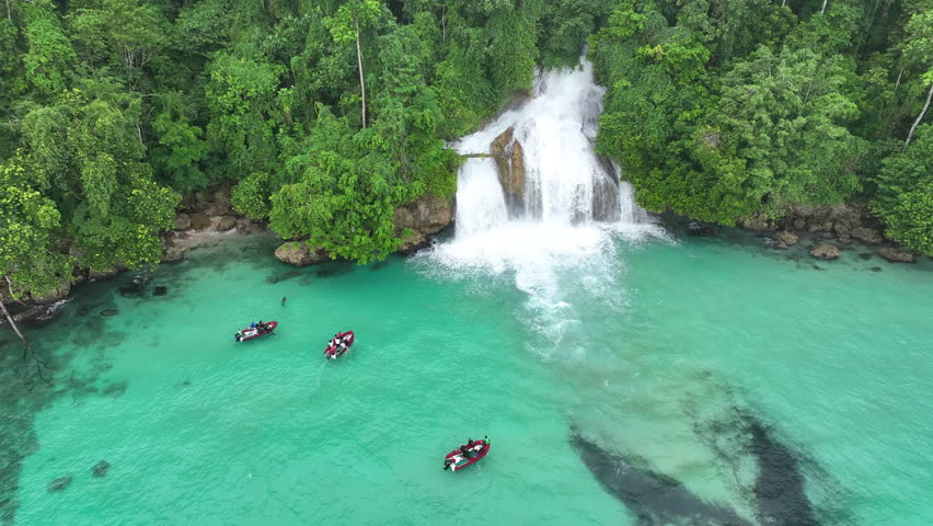 The beautiful Momon waterfall tumbles from the primordial rainforest of West Papua into the shallow sea. This spectacular waterfall is found about a day