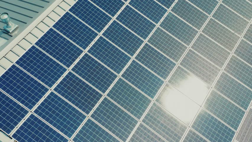 Aerial View Sun Reflects Light.Green Renewable Energy Theme. Solar Power Plant on the Roofs of a Small Industrial Building. Aerial View of Solar Panels on the Roof of a House in the European Area. Royalty-Free Stock Footage #1106213669