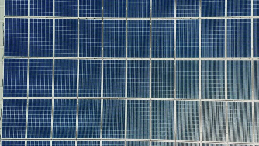 Aerial View Sun Reflects Light.Green Renewable Energy Theme. Solar Power Plant on the Roofs of a Small Industrial Building. Aerial View of Solar Panels on the Roof of a House in the European Area. Royalty-Free Stock Footage #1106213701