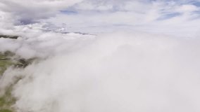 Forward movement. Aerial time lapse view of movement in the clouds on a sunny day. Video background flight in thick clouds