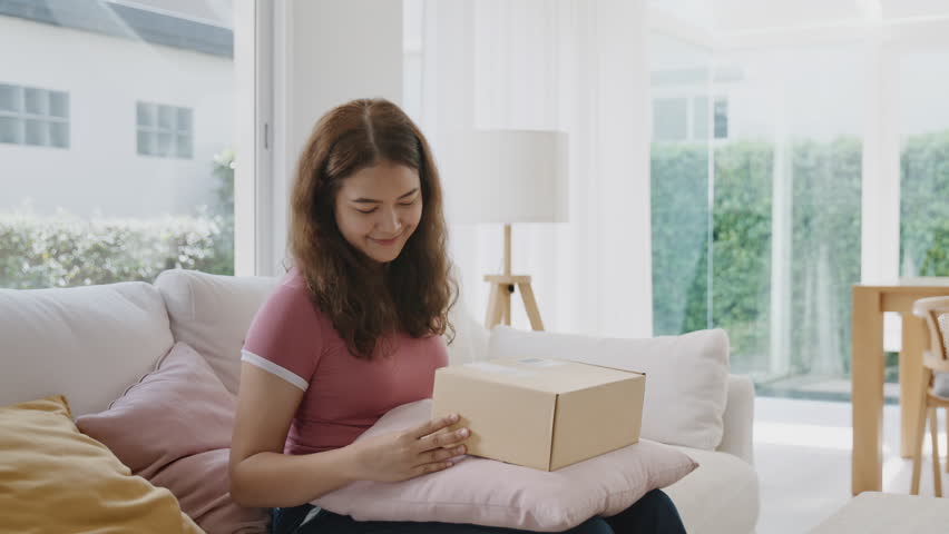 Asia people young Gen Z woman smile open unbox unpack parcel box goods carton packaging happy joy face. Omni channel enjoy buy gift order postal at retail online shop store send courier home service. | Shutterstock HD Video #1106223117