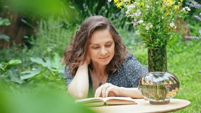 A young woman reading a book while sitting in the backyard of a village house. - Powered by Shutterstock - Get 15% off with code: PIKWIZARD15