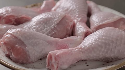Fresh raw chicken legs on a plate. Rotating table : vidéo de stock