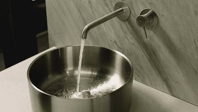 Pouring splashing of washing water in sink . Water pours from tap. Water stream going down the drain.  Clear, clean water flows from the tap. Footage for plumbing system service advertisement - Powered by Shutterstock - Get 15% off with code: PIKWIZARD15