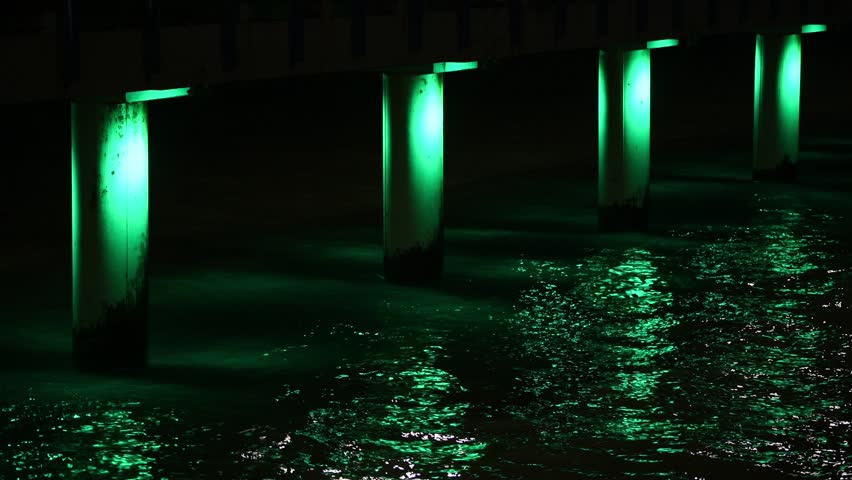 Sea pier with multicolored twinkling lights at night, seashore at night with pier in multicolored illumination, beautiful pier decoration at evening romantic walk, colorful pier support poles