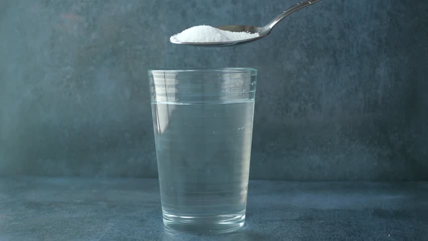 pouring white sugar in a glass of water on table  Royalty-Free Stock Footage #1106241621