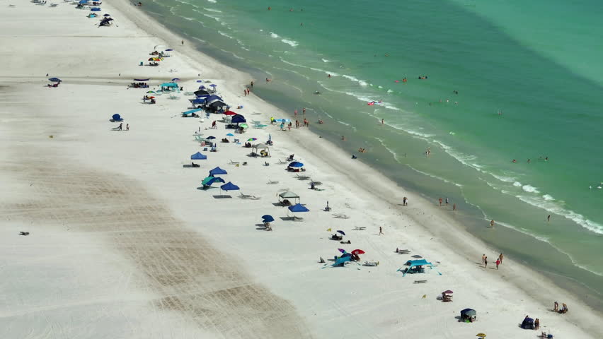High angle view of crowded Siesta Key beach in Sarasota, USA. Many people enjoing vacations time swimming in ocean water and relaxing on warm Florida sun