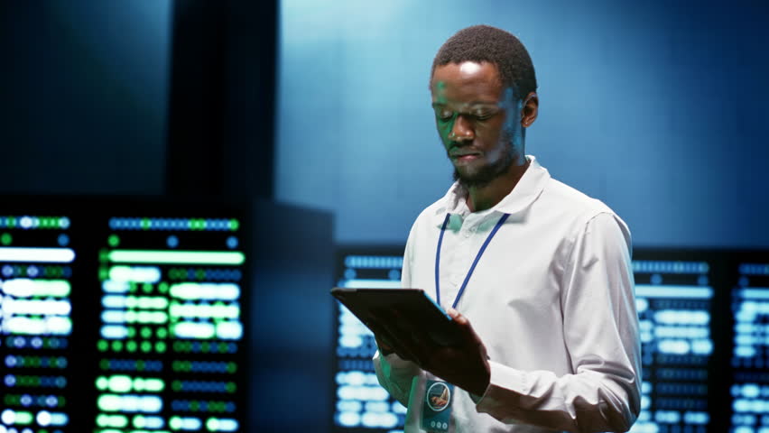 African american specialist using tablet to check data center security features protecting against unauthorized access, data breaches, DDoS attacks and other cybersecurity threats Royalty-Free Stock Footage #1106252685