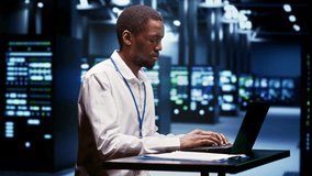 Computer scientist using laptop to debug servers cabinets helping companies manage databases, host websites and store files. Repairman reviewing high tech facility used for high performance computing - Powered by Shutterstock - Get 15% off with code: PIKWIZARD15