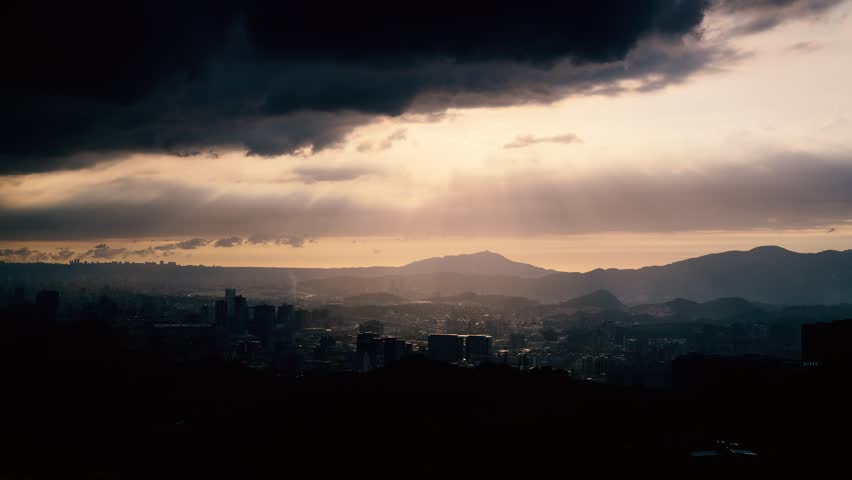 Dynamic Crepuscular Ray and silhouette of Guanyin Mountain. The sky of Taipei. View of the urban landscape from Dajianshan Mountain, New Taipei City, Taiwan