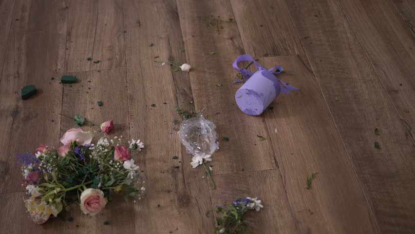 Barefoot legs of young depressed woman walking on wooden floor with broken bouquet kicking flowers leaving in slow motion. High angle view unrecognizable Caucasian sad desperate lady at home indoors | Shutterstock HD Video #1106262593