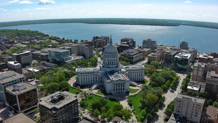 An aerial shot of the Wisconsin State Capitol building surrounded by trees and tall buildings