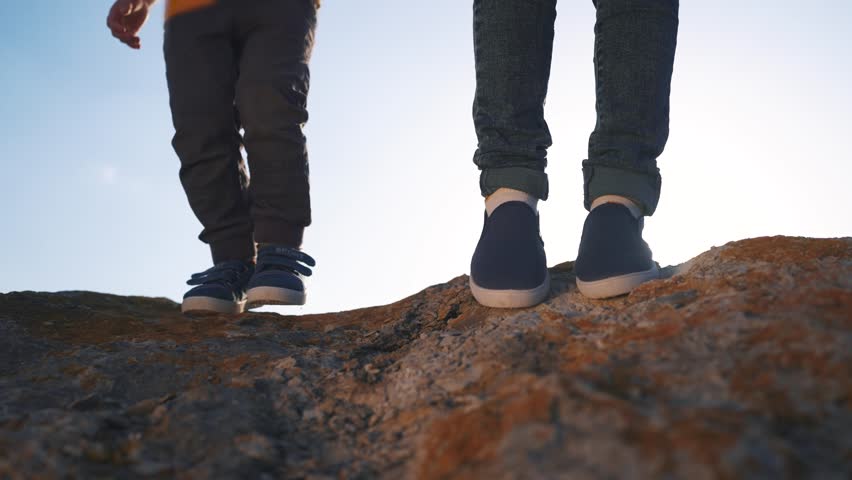 baby boy playing in mountains rocks park. close-up child feet walking on mountains rocks. happy family kid dream concept. a child in sneakers lifestyle walks on mountains rocks park