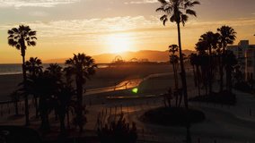Establishing Aerial View Shot of Los Angeles LA CA, L.A. California US, Santa Monica, Santa Monica Beach, sun setting sunset, palm trees, rise up crane shot