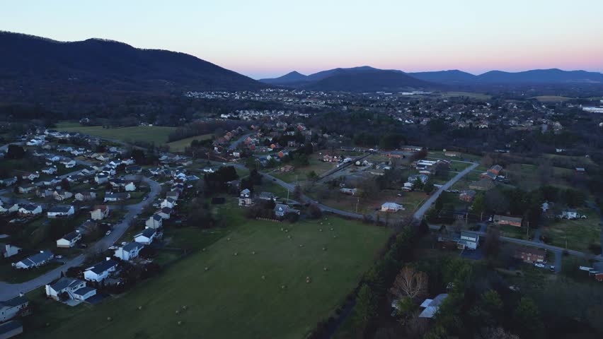 A drone view of Roanoke neighborhood with beautiful Mountains at sunset in Virginia, USA