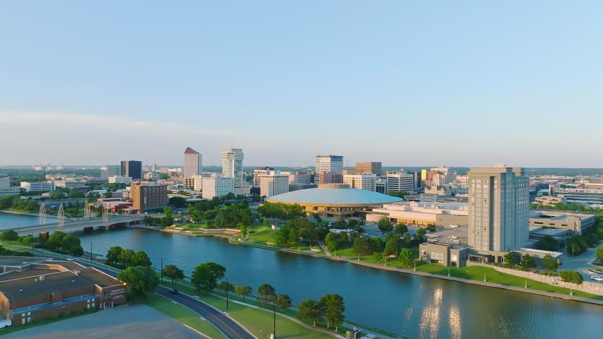 The drone footage over the Arkansas river running through the Wichita city downtown under the blue sky