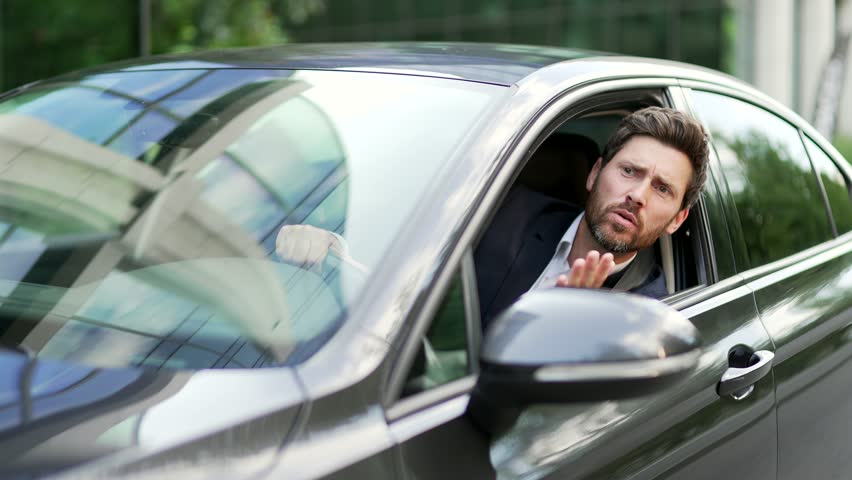 Furious angry man standing in a traffic jam beeps and hurries. Sitting in the car. Irritated nervous mature adult business male in suit tired driver in automobile. Stressful commuting to be late work Royalty-Free Stock Footage #1106282411