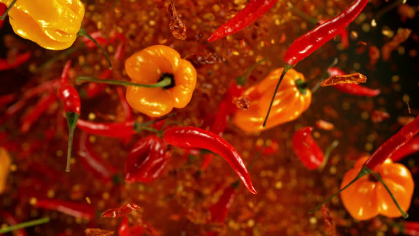 Super Slow Motion Shot of Flying Fresh Chilli Peppers Isolated on Black Background at 1000 fps.