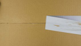 Unpacking carton box with chromakey inside. Hand tears off adhesive tape from a cardboard box, view from the top - Powered by Shutterstock - Get 15% off with code: PIKWIZARD15