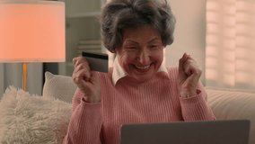 Happy Caucasian old woman senior granny elderly female mature lady retired grandmother with laptop and bank credit card paying online shopping with computer buying internet payment celebrate at home - Powered by Shutterstock - Get 15% off with code: PIKWIZARD15