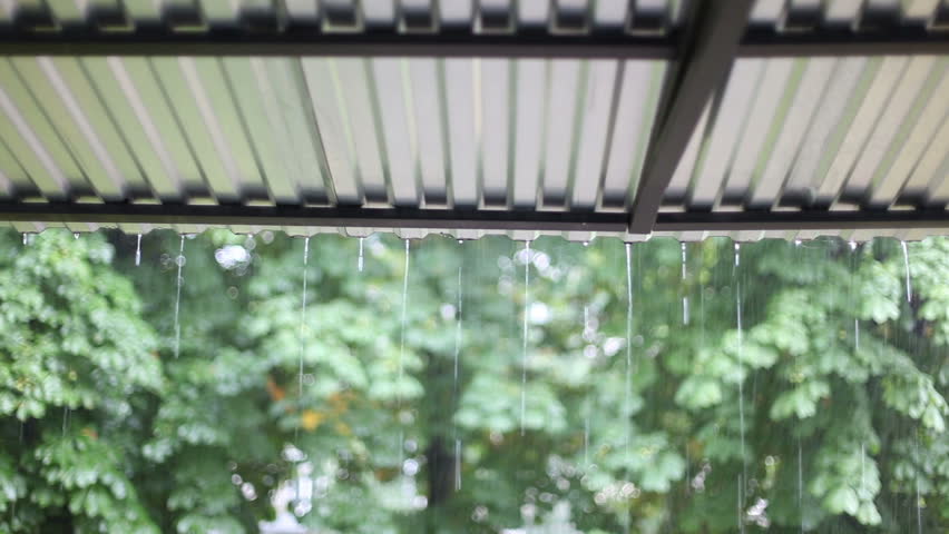 Summer rain drumming on the metal roof. Rainwater flows down from the metal canopy. Royalty-Free Stock Footage #1106285805
