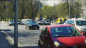 Blurred background video. An ambulance drives along a busy city street with blue flashing beacons on