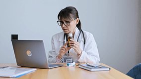Mature woman doctor using laptop for online consultation