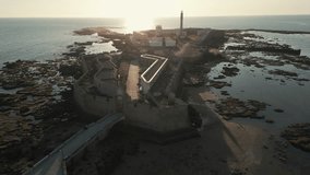 Aerial video of sunset at the Avanzada de Santa Isabel surrounded by the Atlantic Ocean, Cadiz, province of Andalusia, Spain.