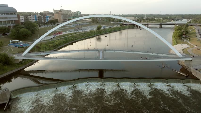 Iowa Women of Achievement Bridge over Des Moines River in Des Moines, Iowa revealing Iowa state capitol with drone video panning.