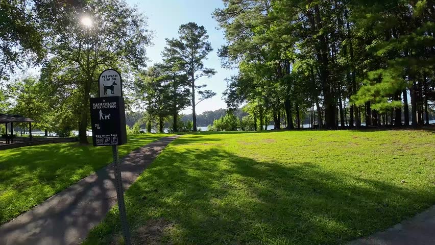 aerial FPV footage of a gorgeous summer landscape at Proctor Landing park with a lake, lush green trees, grass and plants with blue sky and clouds at Lake Acworth in Acworth Georgia USA