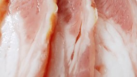 A macro video of the raw bacon. The intricate patterns and perfectly aligned fat streaks create a visually stunning display, evoking a symphony of flavors. Pork concept. Bacon background. 4K HDR
